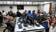 Stockbrokers monitor share prices on computers during a trading session at the Pakistan Stock Exchange (PSX) in Karachi on April 9, 2025. (Photo by Rizwan Tabassum / AFP)

