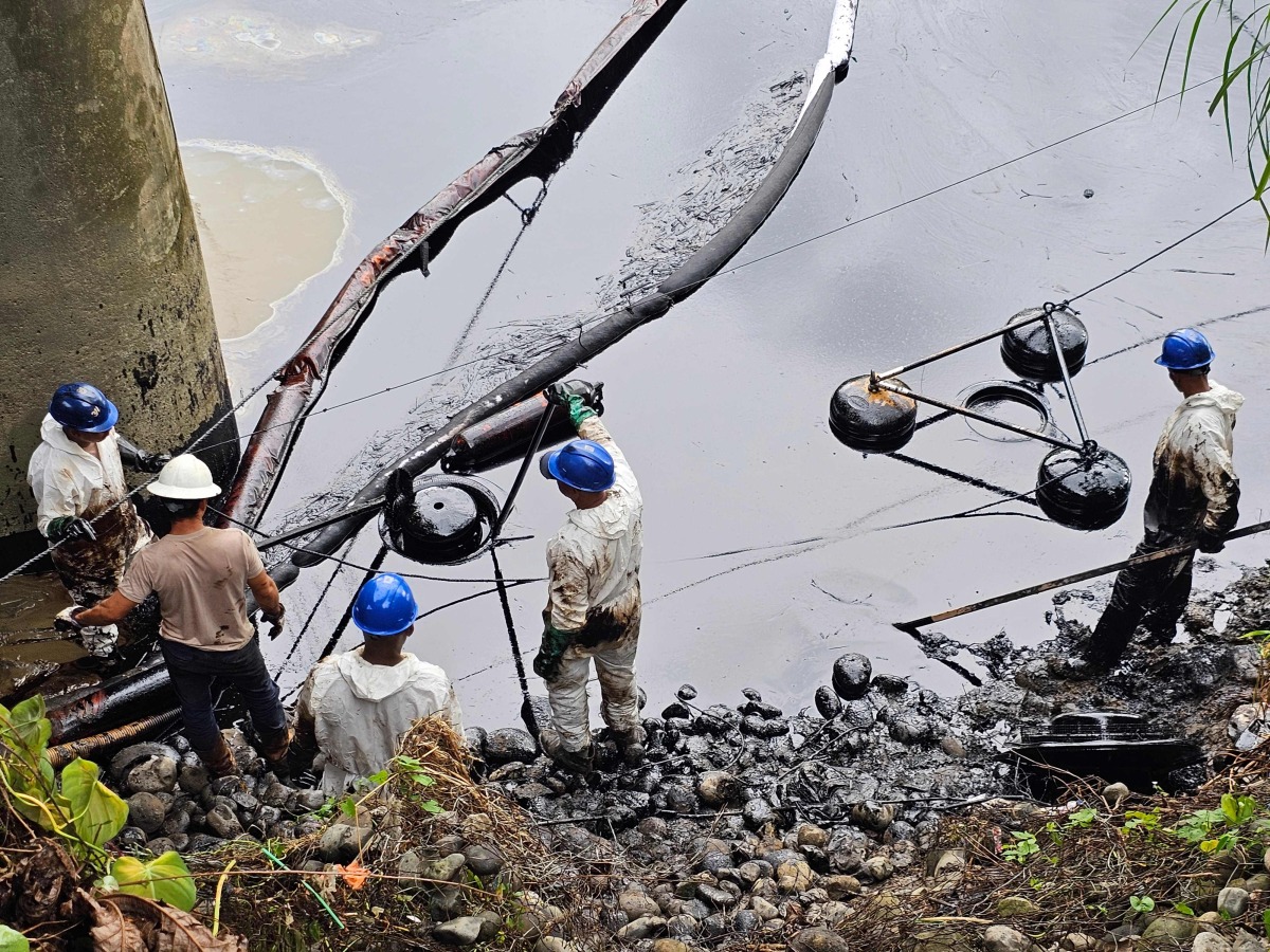 Workers of Petroecuador work on the cleaning of an oil spill at the Viche River in the province of Esmeraldas, Ecuador on March 15, 2025. Photo by Julio Galarza / AFP