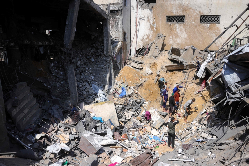 People search for survivors in the rubble of a building destroyed in an Israeli strike in Jabalia, in the northern Gaza Strip on March 18, 2025. (Photo by Bashar Taleb / AFP)
