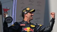 Red Bull Racing's Australian driver Daniel Ricciardo holds the trophy as he celebrates taking first place at the Formula One Malaysian Grand Prix in Sepang on October 2, 2016. (AFP / MOHD RASFAN)