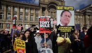 Anti-conservative protesters hold placards during a rally in Victoria Square in Birmingham, central England, on October 2, 2016 on the first day of the Conservative party annual conference.  AFP / DANIEL LEAL-OLIVAS
