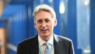 British Chancellor of the Exchequer Philip Hammond walks along the bridge from the hotel to the International Convention Centre in Birmingham, central England, on October 2, 2016 on the first day of the Conservative party annual conference. Britain's gove