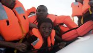 A child cries as migrants are being rescued by members of Proactiva Open Arms NGO in the Mediterranean Sea, some 12 nautical miles north of Libya, on October 4, 2016. AFP / ARIS MESSINIS