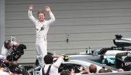 Mercedes AMG Petronas F1 Team's German driver Nico Rosberg waves whilst standing in his car after winning the Formula One Japanese Grand Prix race in Suzuka on October 7, 2016. AFP / BEHROUZ MEHRI