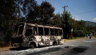 Men walk past a bus that was torched during protests in the town of Sebeta, Oromia region, Ethiopia, October 8, 2016. REUTERS/Tiksa Negeri
