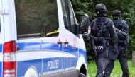 Policemen of a special unit are pictured at the Yorckgebiet district of Chemnitz, eastern Germany, where German police commandos hunting a fugitive Syrian bomb plot suspect raided a flat on October 9, 2016. Germany OUT/ AFP / dpa / Hendrik Schmidt
