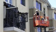 Workmen examine the damage at the scene of a 4th-story apartment building balcony collapse in Berkeley, California June 16, 2015. REUTERS/Elijah Nouvelage.