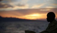 This handout picture taken and released by the Italian Red Cross on October 22, 2016 shows a migrant wrapped in a survival foil blanket after landing in Vibo Marina, southern Italy, following a rescue operation in the Mediterranean Sea. / AFP photo.