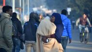 Migrants talk during the full evacuation of the 