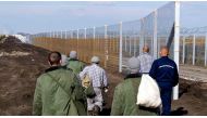 Prisoners build a new, second fence at the Hungarian-Serbian border near Gara village on October 27, 2016 as part of its efforts to keep migrants and refugees from freely entering the country. AFP / CSABA SEGESVARI