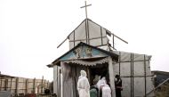 Ethiopian Coptic migrants arrive for a mass at the makeshift Orthodox church in the Jungle