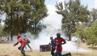 Kenyan human rights activists run from anti-riot police in Nairobi on November 3, 2016, during a demonstration calling for President Uhuru Kenyatta to have more effective actions against political corruption. / AFP / SIMON MAINA