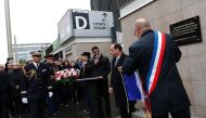 French President Francois Hollande (2L) and Saint-Denis Mayor Didier Paillard (R) unveil a commemorative plaque outside the Stade de France stadium, in Saint-Denis, north of Paris, on November 13, 2016, during a ceremony to mark the first anniversary of t