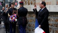 French President Francois Hollande unveils a commemorative plaque next to the 