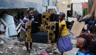 Women carry their belongings from a building next to a building that collapsed in the Huruma estate of the Mathare slum Nairobi Kenya May 3 2016 EPA