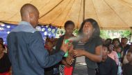 Lethebo Rabalago sprays Doom on a congregant at Mount Zion General Assembly (Photo courtesy: heraldlive.co.za)