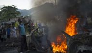 A protestor fuels a burning barricade in the Musaga neighbourhood of Bujumbura, Burundi. 
