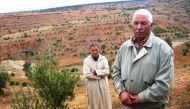 Ait Bella Omar (right), president of the Amghras civic forum, shows off olive trees, planted to prevent erosion of steep mountain slopes in Amghras, Morocco, Nov. 13, 2016. TRF/Megan Rowling