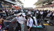 Mercedes AMG Petronas F1 Team's British driver Lewis Hamilton (C-L) talks to a member of his team ahead of the start of the Abu Dhabi Formula One Grand Prix at the Yas Marina circuit on November 27, 2016. / AFP / Andrej ISAKOVIC
