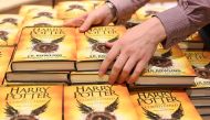 A store assistant holds copies of the book of the play of Harry Potter and the Cursed Child parts One and Two at a bookstore in London, Britain on July 31, 2016. REUTERS/Neil Hall/File Photo
