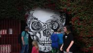 (FILES) This file photo taken on December 14, 2016 shows people walking by a mural at the Museum of Death in Hollywood, California. AFP / Mark Ralston 