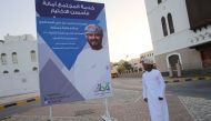 An Omani man walks past an election campaign billboard for the candidate Qais bin Mohammed bin Ali Almashry, in Muscat on December 23, 2016.  AFP / MOHAMMED MAHJOUB
