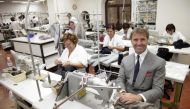 File photo of Italian clothing designer Brunello Cucinelli posing as seamstresses in the Umbrian village of Solomeo October 7, 2009. Reuters/Alessandro Bianchi
