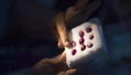 This photo taken on November 22, 2016 shows a buyer looking at rubies in a jade market in Mandalay. AFP / Ye Aung Thu