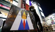 A Japanese graffiti artist known as 281 Antinuke poses for a photo with his sticker art depicting U.S. President Donald Trump in Tokyo's Shibuya shopping and entertainment district, Japan, January 27, 2017. Reuters/Toru Hanai 