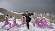 In this photograph taken on January 29, 2017, Afghan members of a wushu martial arts group led by trainer Sima Azimi (C), 20, pose for a photograph at the Shahrak Haji Nabi hilltop overlooking Kabul. AFP / WAKIL KOHSAR