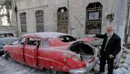 A picture taken on March 9, 2017, shows 70-year-old Mohammad Mohiedine Anis opening the trunk of his 1949 Hudson Commodor outside his home in Aleppo's formerly rebel-held al-Shaar neighbourhood. AFP / JOSEPH EID