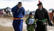 This picture taken on March 5, 2017 shows a Mongolian child jockey (C) preparing to compete in the 