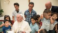 FILE PHOTO: Pope Francis reading a book to Syrian refugee children at the Vatican ( Casa Santa Marta via AFP) 