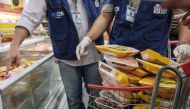 The staff of Rio de Janeiro state's consumer protection agency, PROCON, inspect and remove chicken products that are not frozen from a freezer at a supermarket in Rio de Janeiro, Brazil, on March 24, 2017. Brazil, the world's biggest beef and poultry expo