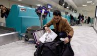 A Libyan traveller packs his laptop in his suitcase before boarding his flight for London at Tunis-Carthage International Airport on March 25, 2017. / AFP / FETHI BELAID
