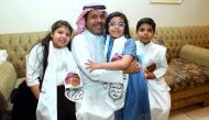 Saad al-Ajmi (C), former spokesman of the opposition Popular Action Movement, hugs his children upon his return home on March 30, 2017, south of Kuwait City. Ajmi, who was deported to Saudi Arabia after revoking his citizenship was allowed to return home 