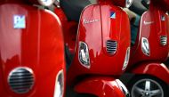 Red Vespa parked in a street of Rome, on December 9, 2013.  AFP / Gabriel Bouys

