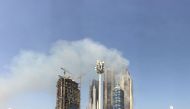 Smoke billows near the Dubai Mall and Burj Khalifa, the world's tallest building, after a fire hit the construction site in Dubai on April 2, 2017. A blaze erupted in a residential complex under construction near Dubai's biggest shopping mall and a hotel 