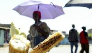 A woman walks past roasted corn for sale in Kenya's capital Nairobi July 14, 2009. REUTERS/Noor Khamis