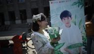 A woman handing out leaflets during an event for fans of China's boy band sensation TFBoys 