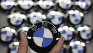 An employee holds a BMW logo on the production line of the BMW C evolution electric maxi-scooter at the BMW Berlin motorcycle plant February 23, 2015. REUTERS/Fabrizio Bensch
