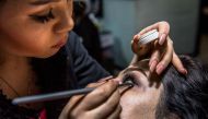 An Afghan beautician applies eye make-up for a client at a beauty parlour in Kabul on March 23, 2017. AFP / Rebecca Conway 