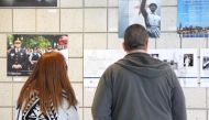 Visitors observe the works of police officers at a Chicago police station exhibition on May 5, 2017. Entitled 