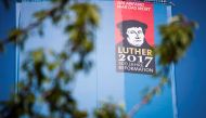 A portrait of Martin Luther is seen on the side of a giant book displaying all the pages of the bible on its back side in the Lutherstadt Wittenberg, eastern Germany, on May 18, 2017. AFP / Odd ANDERSEN