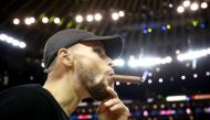 Stephen Curry #30 of the Golden State Warriors smokes a cigar after defeating the Cleveland Cavaliers 129-120 in Game 5 to win the 2017 NBA Finals at ORACLE Arena on June 12, 2017 in Oakland, California.  Ezra Shaw/AFP