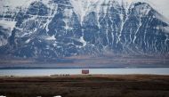 (FILES) This file photo taken on April 10, 2017 shows a house near snow-covered mountain on the Snaefellsjokull peninsula in Iceland. AFP / LOIC VENANCE