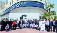 IBQ staff in front of the ‘Tamim Al Majd’ mural at its main branch. 
