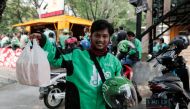 A Go-Jek driver shows boxes with food for his customer in front of a food stall in Jakarta, Indonesia, July 13, 2017. Reuters/Beawiharta