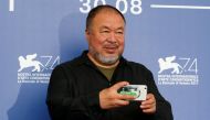 Director Ai Weiwei takes a picture as he poses during a photocall for the movie 