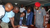 Fontem Aforteka'a Neba (3rd L) and Felix Agbor Balla (2nd R) two Anglophone activists leaders prepare to sign a document during their release at the prison of Yaounde, Cameroon, September 1, 2017. REUTERS